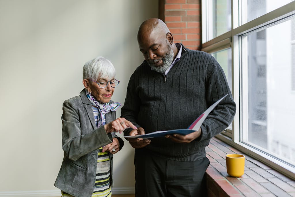 An Elderly Man and Woman Having Conversation while Looking at the Folder